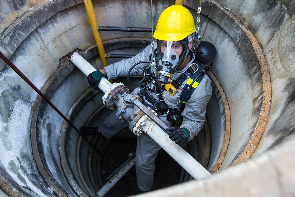 Trabalhador em espaço confinado com equipamento de ar