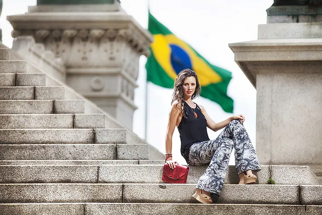 Fotógrafo de moda em Mairiporã: modelo na escadaria com a bandeira do Brasil